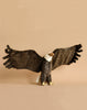 The Large Eagle Stuffed Animal features realistic brown wings and a white head, standing with outstretched wings against a simple beige backdrop, highlighting its distinct personality.
