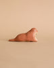 The Handmade Wooden Walrus, brown with simple features, rests on a plain matching background. Crafted like a timeless toy with child-safe paint, it captures the essence of natural beauty artfully in every detail.