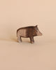 A handcrafted Ostheimer Wild Boar figurine, displayed against a soft beige background, featuring detailed textures and a lifelike pose.