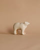 A minimalist wooden sculpture of a polar bear on a beige background. With an abstract, handcrafted toy-like style, it features smooth, rounded edges and a glossy finish. Product: Handmade Wooden Polar Bear.