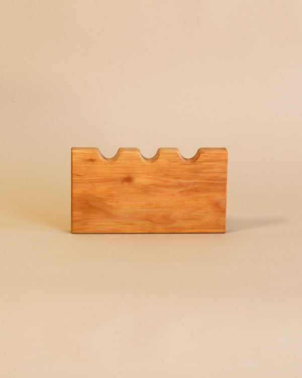 A Ostheimer Castle Wall with undulating top edge, designed like handcrafted wooden toys, set against a plain, light beige background.