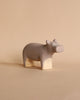 The Handmade Wooden Hippo is a small, minimalist sculpture with a smooth, pale brown surface and soft, rounded features. It is crafted with child-safe paint against a plain beige background.
