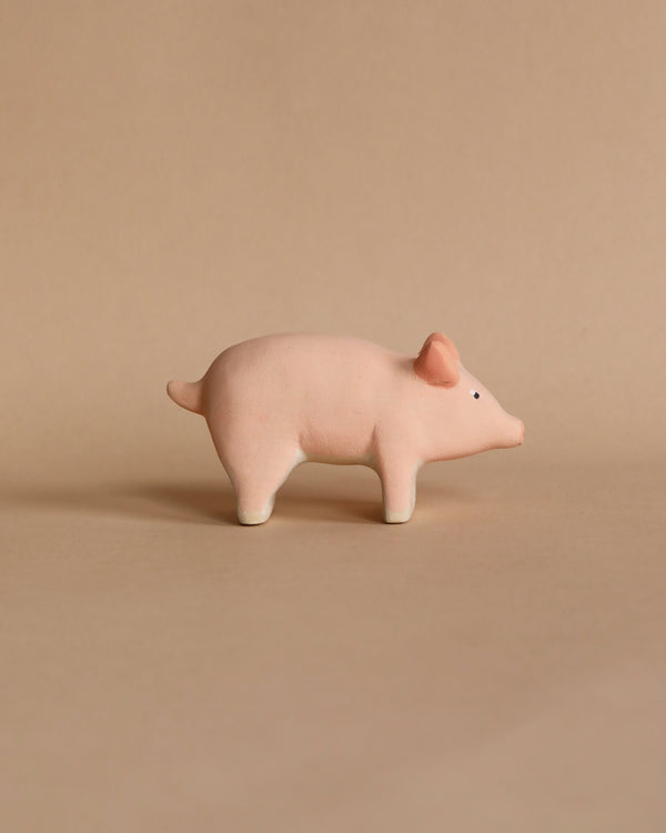 The Handmade Wooden Pig figurine features a round body, short tail, and upward-facing snout with child-safe paint, set against a plain beige background for a minimalist aesthetic.