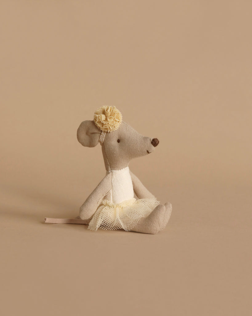 A small beige fabric mouse from the Maileg Little Sister Bedtime Set, dressed in a cream tutu and matching flower headband, sits on a plain beige background, perfect for bedtime play or pairing with other Maileg accessories.