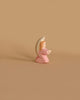 The Ostheimer Little Angel - Pink is a small, wooden figurine painted in soft pastel colors. This angel features light brown hair, a white halo, and wears a pink robe. Handcrafted from sustainably sourced materials, it stands in a prayerful stance with hands clasped together against a plain beige background, reminiscent of the charming style of Ostheimer toys.