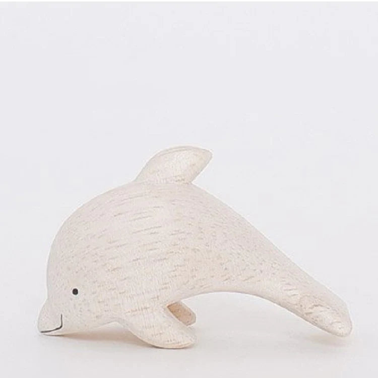 A Handmade Tiny Wooden Dolphin, hand-carved from eco-responsible forests, featuring a simple, smooth design with subtle wood grain texture, and a cheerful expression crafted with a small dot for an eye.