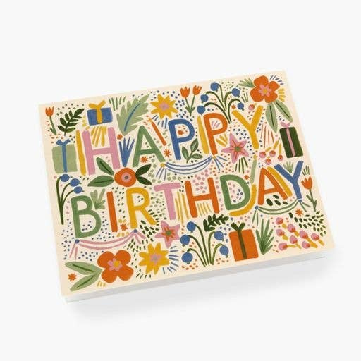 The Fiesta Birthday Card features "HAPPY BIRTHDAY" in bold letters with vibrant flowers, leaves, and gift box illustrations on a white background. Comes with a metallic gold envelope for an elegant touch.