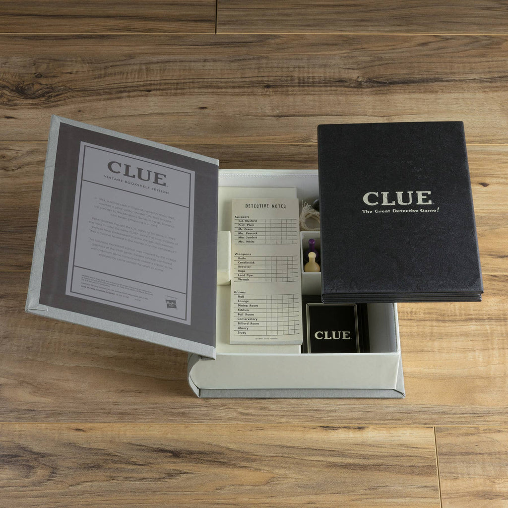 An open Clue Vintage Bookshelf Edition box sits on a wooden surface, showing off its premium components: a rulebook, detective notes, character pawns, dice, cards, and more—perfect for any aspiring crime solver.