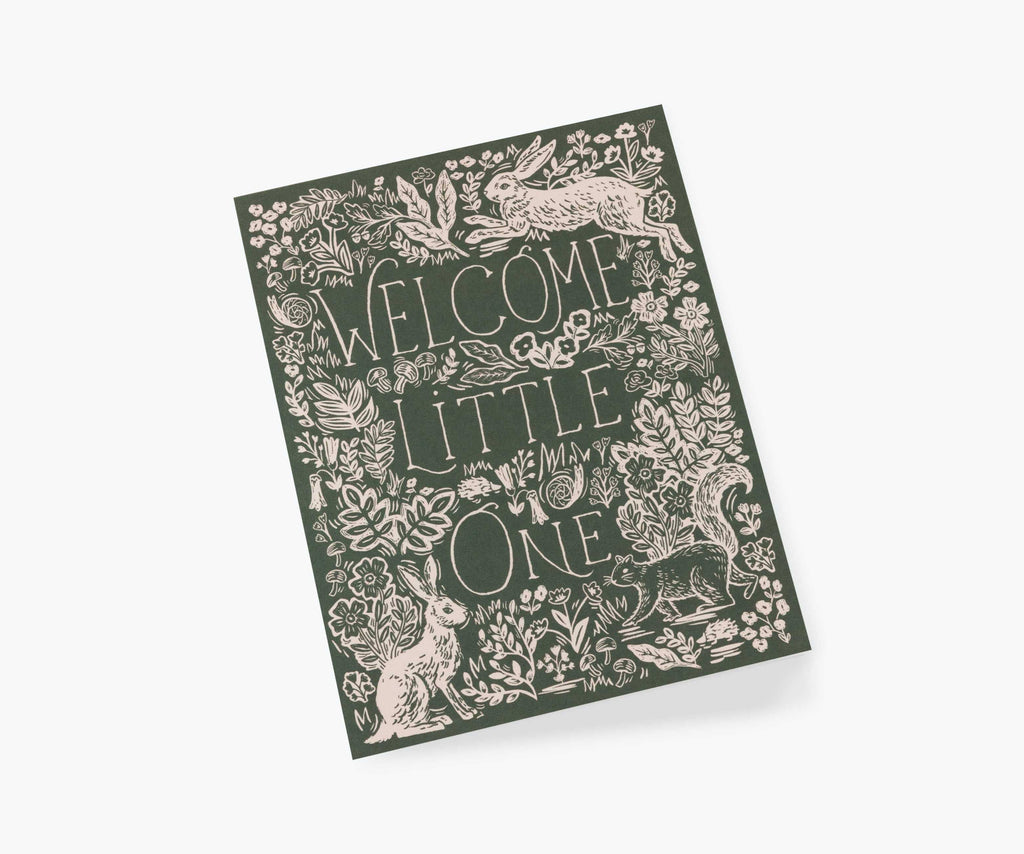 The Fable Baby Card features "Welcome Little One" amid flowers, leaves, and forest animals on a dark green background. With a blank interior, it’s ideal for your personal message.
