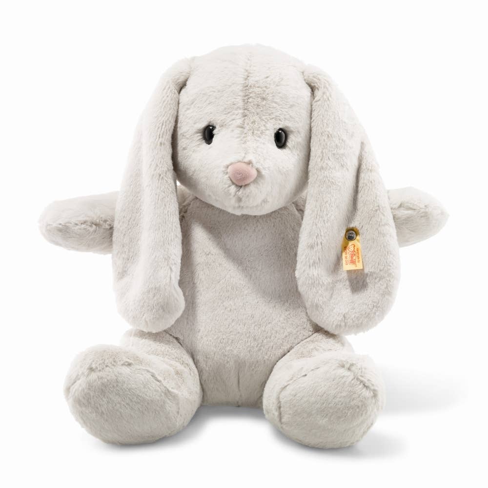 The Steiff Hoppie Bunny Stuffed Animal is a plush, light gray bunny with long floppy ears, black eyes, a pink nose, and a small yellow tag on its left ear—perfect for any plush toy lover.