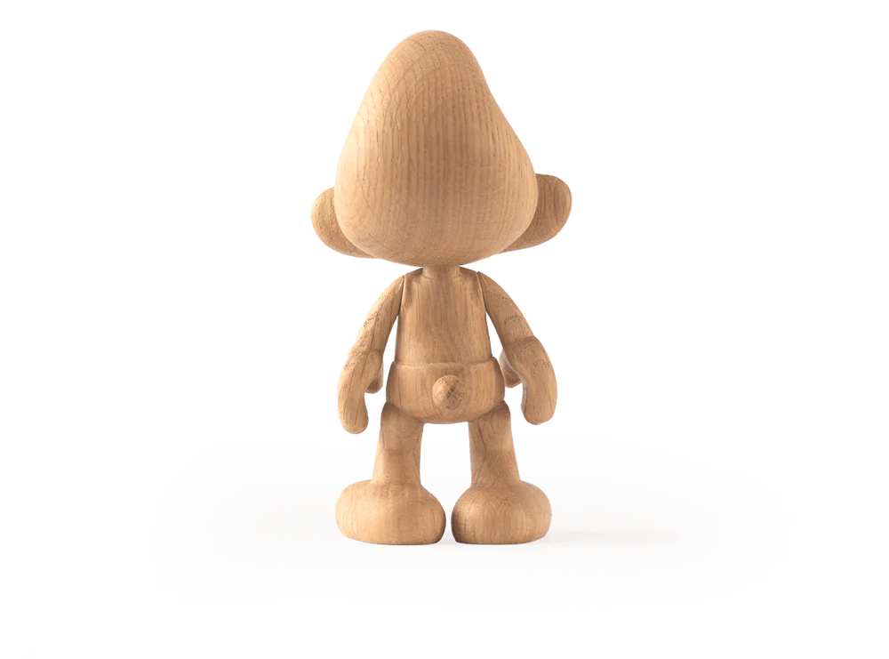 The Smurf, Oak figurine displays a cartoonish, cheerful character with a round head, pointy hat like those from Smurf Village, large ears, and rounded feet. Its wood grain texture enhances the handcrafted charm as it stands proudly on a white surface from the back view.