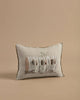 The Coral & Tusk Aspen Log Bunnies Pocket Pillow is crafted from 100% linen and features an embroidered design of three birds in a hollow log. The intricate brown, gray, and black stitching contrasts beautifully with the simple beige background.