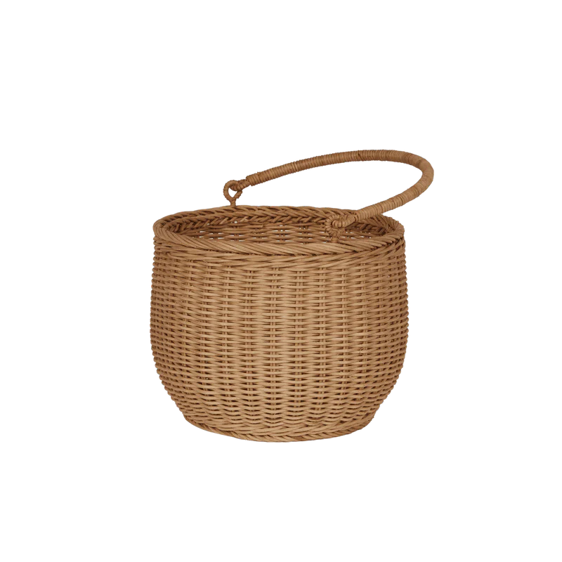 The Olli Ella Gathering Basket is a round, brown rattan basket featuring a woven texture and a sturdy curved handle on top. It's showcased empty against a plain black background.
