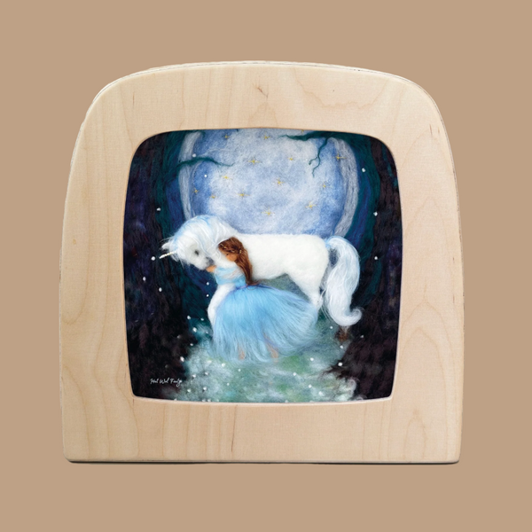 The Silhouette Only - Magical Unicorn for Toverlux Lamp depicts a white unicorn and a girl in a blue dress hugging under a starry sky, framed in light wood, with the background revealing mystical forest silhouettes and a glowing pathway.
