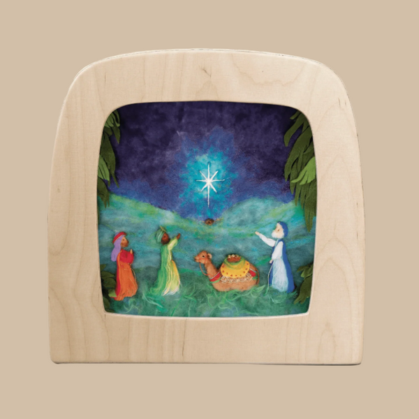 The "Silhouette Only - Three Kings for Toverlux Lamp" shows three figures and a camel admiring a bright star in a dark night sky over green hills, designed to be displayed in a wooden Toverlux frame.