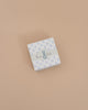 Consider gifting the Maileg Bunny Rattle Set - Mint. This charming small square box features a floral pattern, gray ribbon with a playful blue bunny, and "bunny baby" text on a beige background, perfectly sized to hold soft cotton cloths or the sweet bunny rattle.