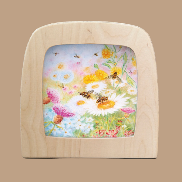 The Silhouette Only - Bee Pastures for Toverlux Lamp is a magic window frame featuring vibrant bees on white daisies with pink, yellow, and blue flowers under a sunny sky. Ships in one week.