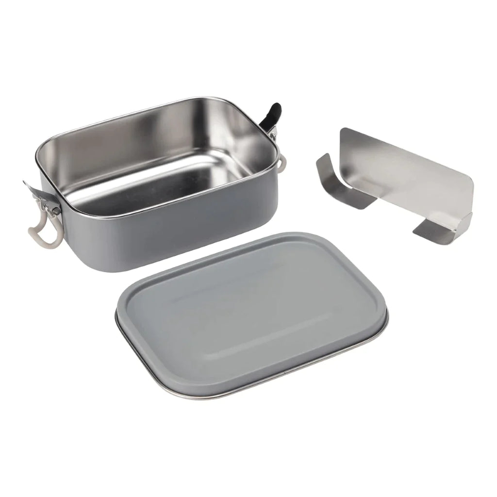 A silver metal bento box with a gray lid is shown open and slightly tilted. This Haps Nordic - Stainless Steel Lunch Box - Ocean features black and white clasps on the sides. The BPA-free lid is placed in front of the leak-resistant lunch box, and a small, separate metal accessory is beside it.