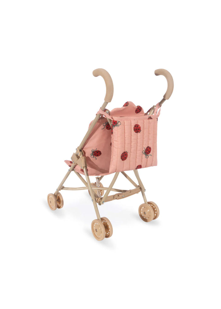 The Konges Sloejd Doll Stroller - Ladybug features adorable floral and ladybug patterns with beige handles and wheels. Its quilted seat fabric adds coziness, while the easy-to-fold design offers convenience, set against a plain white background to highlight its charm.