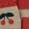 A close-up of a Sonja Knit Mittens - Beige Melange featuring a cherry design with red fruits and green leaves on a beige background, bordered by a textured red section made of mulesing-free merino wool.