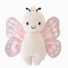 A Cuddle + Kind Baby Butterfly made from Peruvian cotton yarn, featuring a white body, light purple wings with pink and white accents, black stitched eyes, a smiling mouth, and two short black antennae atop its head. This collectible piece sits against a plain white background.