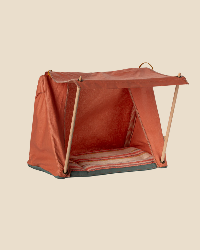 The Maileg Happy Camper Tent - Rust is a fold-up pet tent featuring a striped cushioned base and wooden frame, set against a plain beige background. The open front invites your pet to enjoy a cozy sleepover.