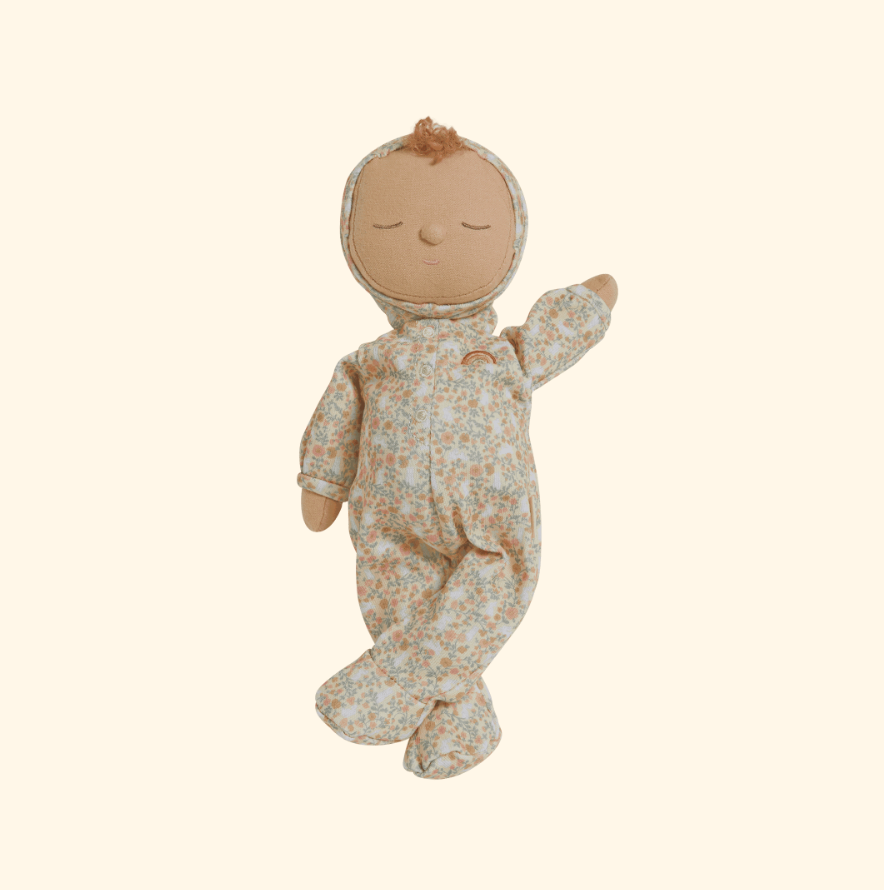 The Olli Ella Dozy Dinkums - Custard - Garden Floral doll, dressed in a charming floral print onesie with a hood, features closed eyes, a tuft of hair, and a gentle smile. It's the perfect peaceful companion for Easter, resting against a neutral background.
