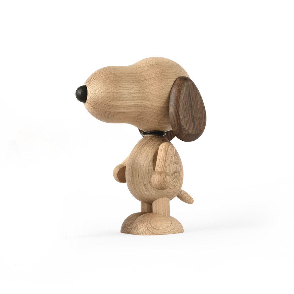 A Boyhood Snoopy, Large stands in profile with parts of its body separated, showcasing how it can be assembled, on a light gray background.