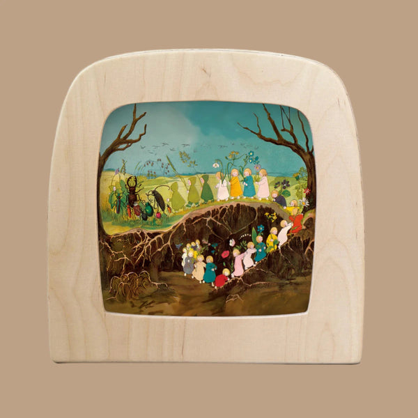 The Silhouette Only - The Story of the Root Children features colorful characters navigating a tree root in a serene forest under blue skies. This vibrant, ethereal scene enhances the enchanting glow of the Toverlux lamp.