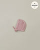 A small pink knitted bonnet, perfect for Minikane Babies, is displayed on a plain light gray background. The text "fits MINKANE 11"" is shown in the upper right corner inside a white circle. The product name is Minikane Doll Clothing | Élie Tea Pink Knit Bonnet.