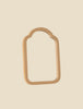 A beige, arch-shaped object with an open center resembles a door frame and is set against a light background. It is reminiscent of the Maileg Living Room Set with rounded top corners and crafted from smooth material.
