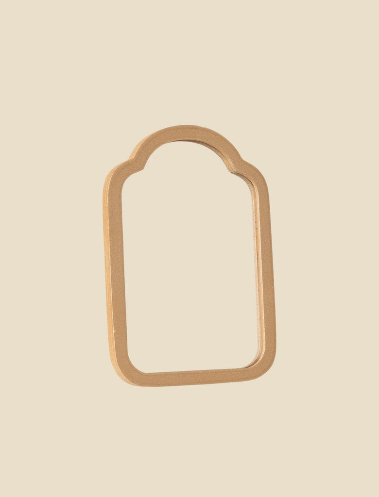 A beige, arch-shaped object with an open center resembles a door frame and is set against a light background. It is reminiscent of the Maileg Living Room Set with rounded top corners and crafted from smooth material.