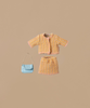 The Maileg Suit For Mum Mouse, featuring a doll-sized yellow and pink tweed jacket and skirt set, is beautifully displayed. Complementing the outfit is a small light blue handbag with a chain strap, all shown against a neutral beige backdrop.
