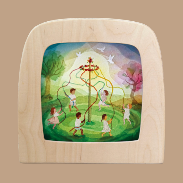 The Silhouette Only - Ribbon Dance for Toverlux Lamp features a colorful illustration of children dancing around a maypole in a vibrant meadow. Birds are silhouetted against the sky, and trees frame the scene, bringing a whimsical and festive atmosphere to any setting.