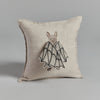 Decorative pillow with an embroidered design of a Bat Wing Surprise Pillow on a neutral linen background, photographed against a gray backdrop.