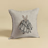 A Bat Wing Surprise Pillow with a beige background featuring an embroidered design of a bat with butterfly wings, showcasing detailed stitching on a neutral-toned fabric.