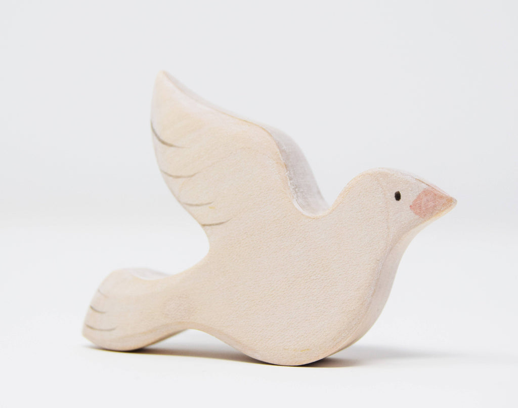The Handmade Wooden Dove is crafted from sustainable hardwood, featuring simple details like a pointed beak and outlined wings, enhanced by natural plant-based stains. It's an exquisite piece against a plain white background, perfect for any bird collection.