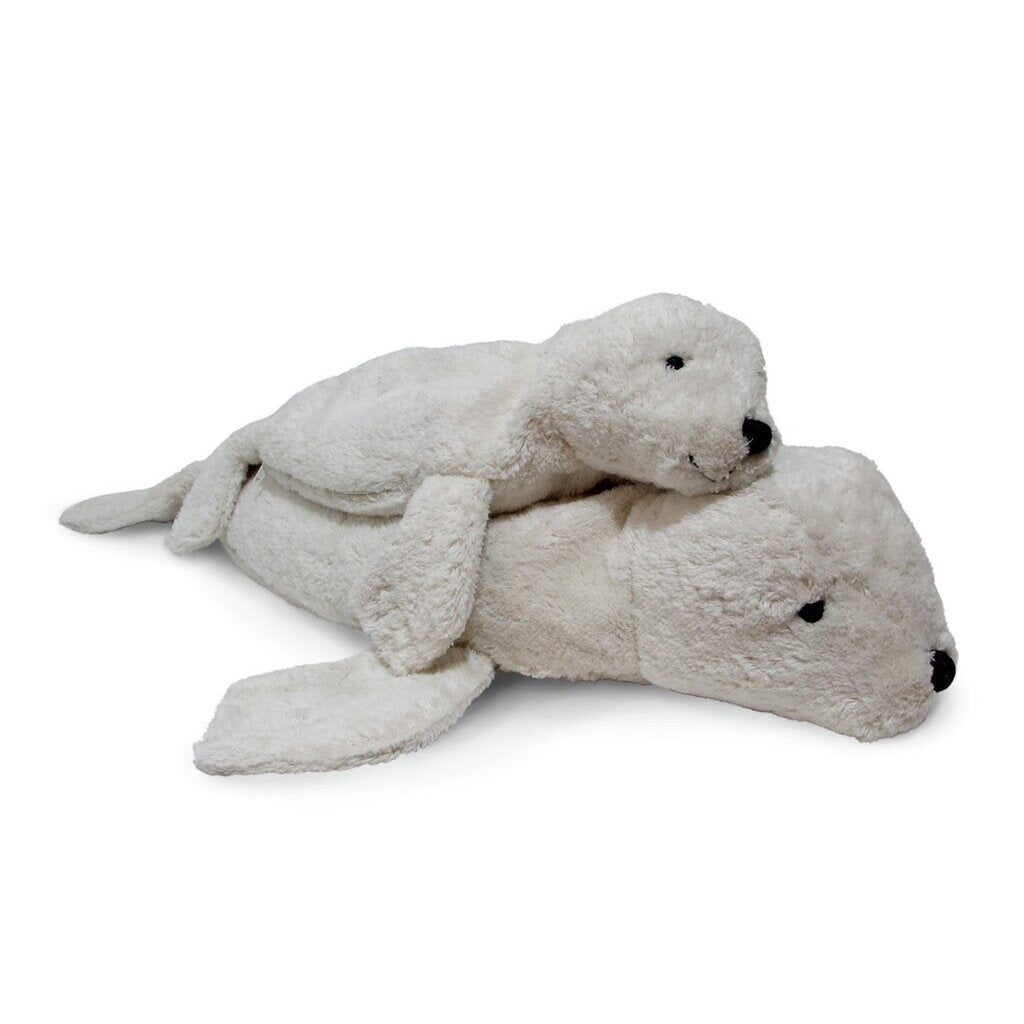 Two Senger Naturwelt Cuddly Animal - White Seal plush toys, crafted from organic cotton, rest on a white background. The smaller seal lies atop the larger; both feature black eyes and noses—ideal for use as snuggly warming pillows.
