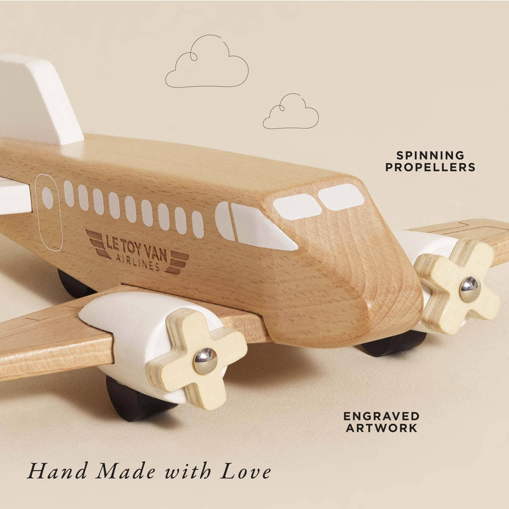 The Wooden Toy Plane is a plastic-free, hand-made toy crafted from FSC-certified wood, featuring spinning propellers, engraved artwork, and “Le Toy Van Airlines” labeling. Shown on a beige background with simple cloud illustrations.