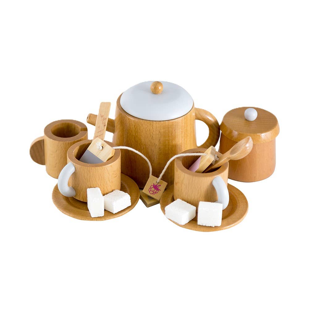 The Wooden Tea Set includes a teapot, two teacups with teabags and saucers, a sugar bowl, and a small container on a white background. Ideal for chai latte moments or pairing with favorite coffee table books; each cup has sugar cubes on the saucers.