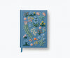 The Menagerie Garden Embroidered Journal features a light blue hardcover with colorful floral and leaf embroidery on the front, plus a matching blue ribbon bookmark.