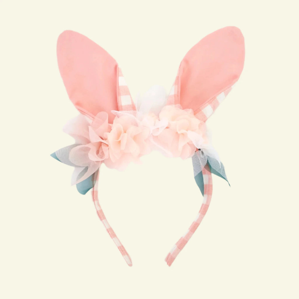 The Embellished Gingham Bunny Headband features a pink bunny ear design with a checkered pattern, pastel pink organza flowers, white blooms, and green leaves on a plain white backdrop.