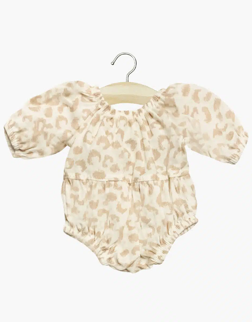The Minikane Doll Clothing Cotton Bertille Romper - Feline features puffed sleeves and elastic leg openings in a light beige and tan leopard print. Made in France, this hand-washable romper is perfect for stylish comfort. Presented on a wooden hanger.
