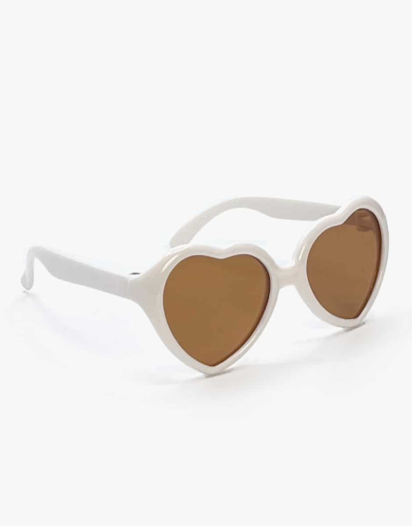 White heart-shaped sunglasses with brown lenses, exuding playful charm akin to Minikane's Jade doll, stand out against a white background.