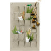 The Gathre Small Advent Calendar - Grove is a beautifully minimalist beige fabric advent calendar featuring 25 gift pockets filled with delightful surprises such as toy cars and sprigs of greenery. With bells elegantly suspended from the top right corner on a rope, this calendar adds a charming touch to your magical Christmas countdown.