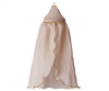 A delicate, light beige Maileg Mini Bed Canopy with a pointed top and flowing fabric draping down from the bedroom ceiling. The edges are adorned with a thin golden decorative trim, making it an elegant bed decoration.