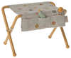 A small, foldable stool with yellow metal legs and a fabric seat featuring multicolored dots. Perfect for a **Maileg Nursery Table, Baby Mouse - Ocher**, it comes with a fabric pouch holding baby accessories like a tiny green bottle and a small orange ball.