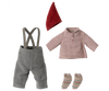 A child's outfit is laid out, featuring cozy clothes: gray pants with suspenders, a red and white checkered long-sleeve shirt, a red pointed hat reminiscent of the Maileg Medium Christmas Mouse, and a pair of knitted socks with a festive red and green pattern.