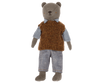 A stuffed bear toy, affectionately known as Teddy Dad, dons a checkered blue and white shirt, a brown knitted vest, and light blue pants. The Maileg Extra Clothing: Shirt, Slipover and Pants for Teddy Dad can also be purchased separately. The bear has a simple facial expression with stitched eyes, nose, and mouth. Its arms and legs are positioned straight.
