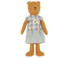 A Teddy Mum dressed in a charming blue and white checkered dress adorned with an embroidered sunflower. The stuffed bear stands upright with its arms at its sides and has a simple, stitched face with a small smile. Maileg Extra Clothing: Dress for Teddy Mum can be purchased separately.